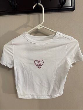 Pristine white baby tee with embroidered broken heart